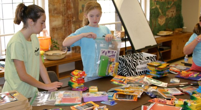 Kids work on creating school kits
