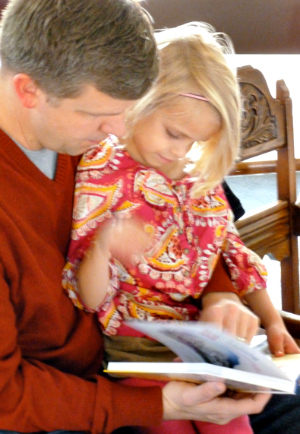 A 3rd grader checks out her new Bible with dad