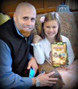 A 3rd grader proudly holds her Bible