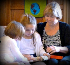Mom with two girls look at a Bible