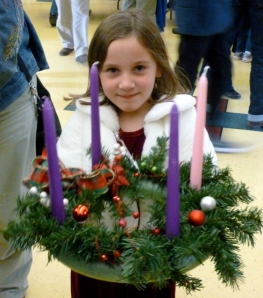 a child holds a newly created Advent wreath
